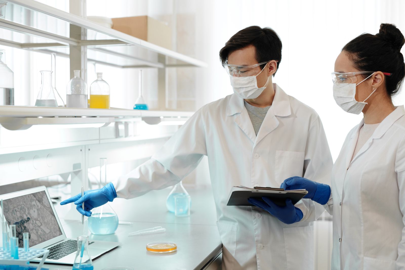 Two scientists examining research images on a laptop